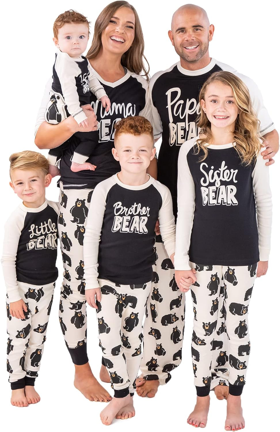 Family wearing matching black and white Family Bear pajamas with bear prints and labeled tops for mom, dad, sister, brother, and little bear baby.