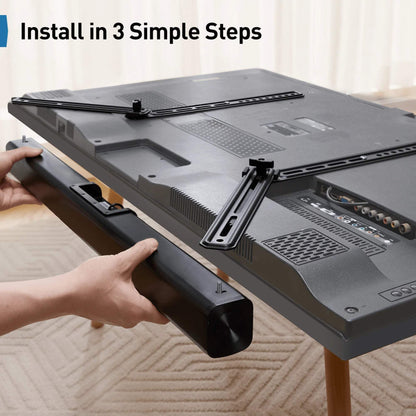Hands installing a universal soundbar mount onto the back of a TV in a home setting